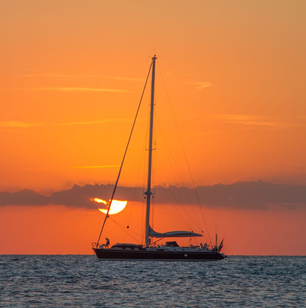Yate a vela navegando al atardecer en alta mar