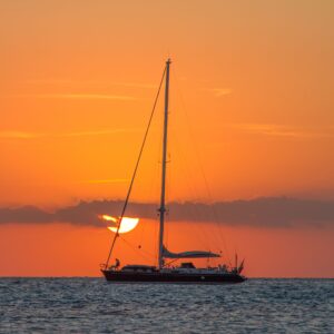 Yate a vela navegando al atardecer en alta mar