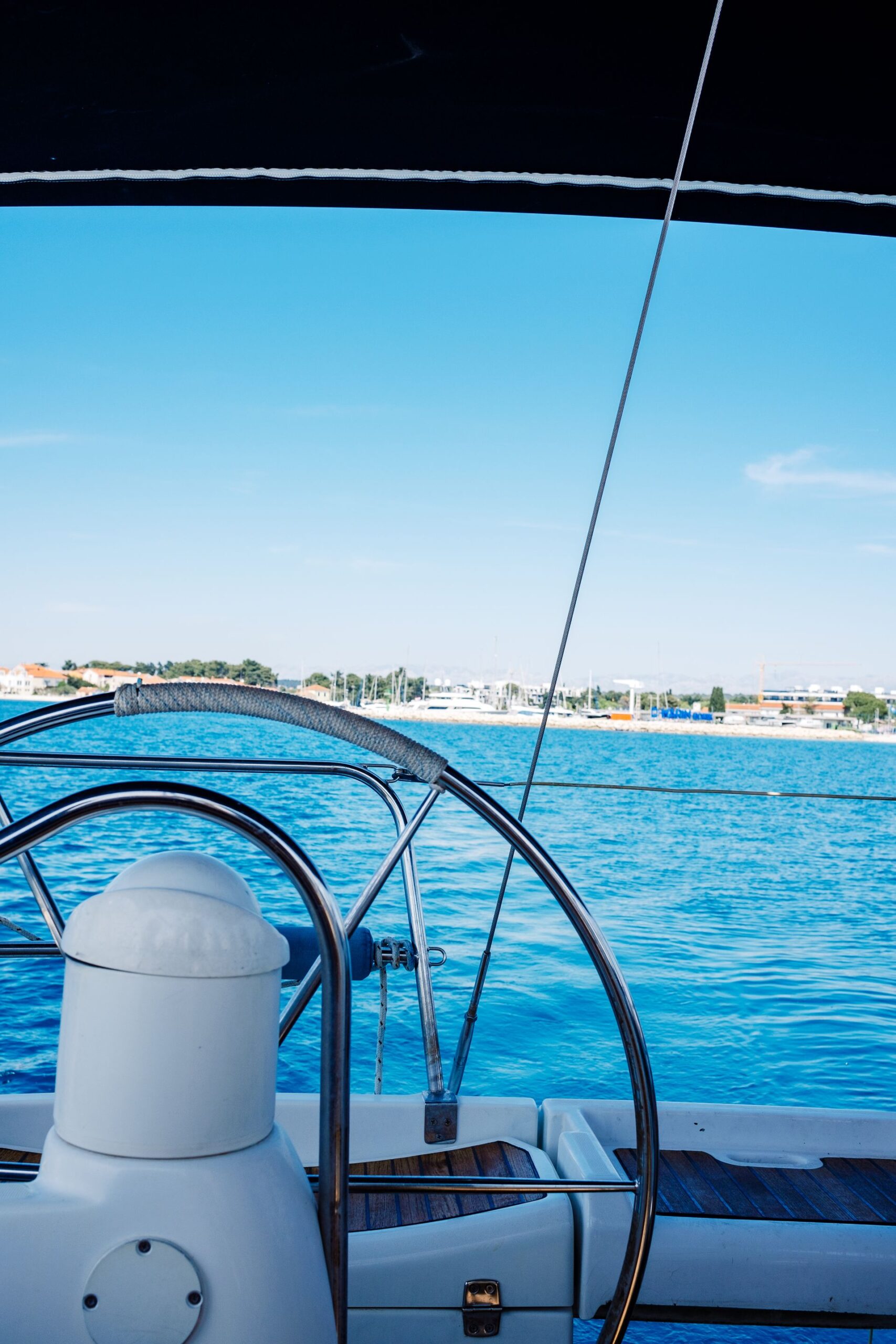 Al timón de un velero en aguas turquesas, con el mar por delante